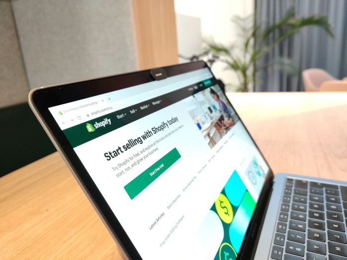Portátil mostrando la web de Shopify con una tienda online, imagen de temas y rendimiento para Shopify